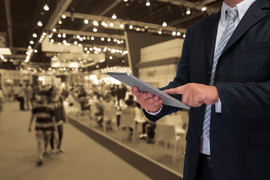 businessman using tablet with blurred event background