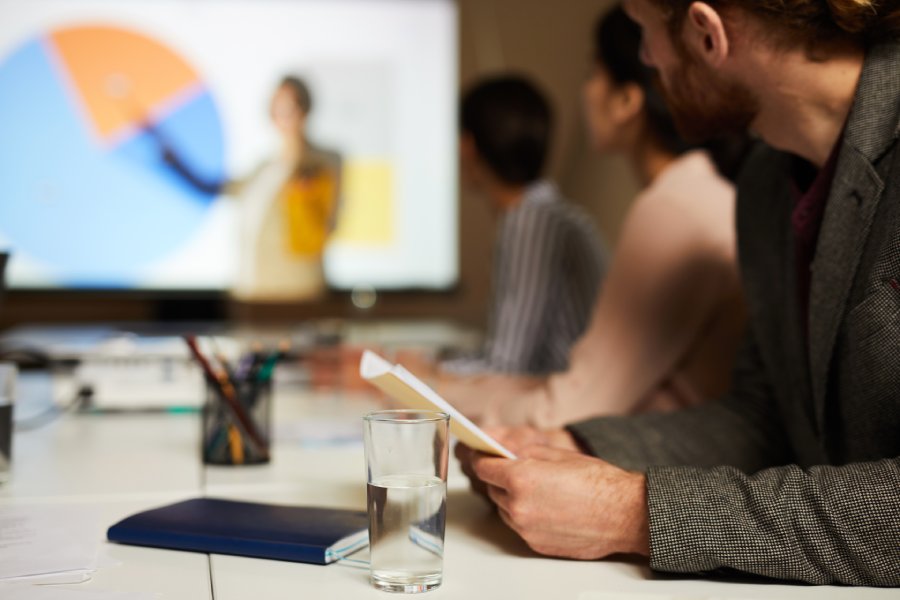 Side view closeup of unrecognizable man listening to presentation in meeting room, copy space