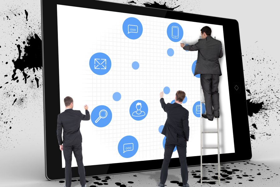 Business team writing against tablet screen
